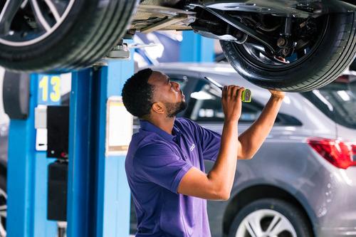 Mechanic checking under car at a cinch service centre